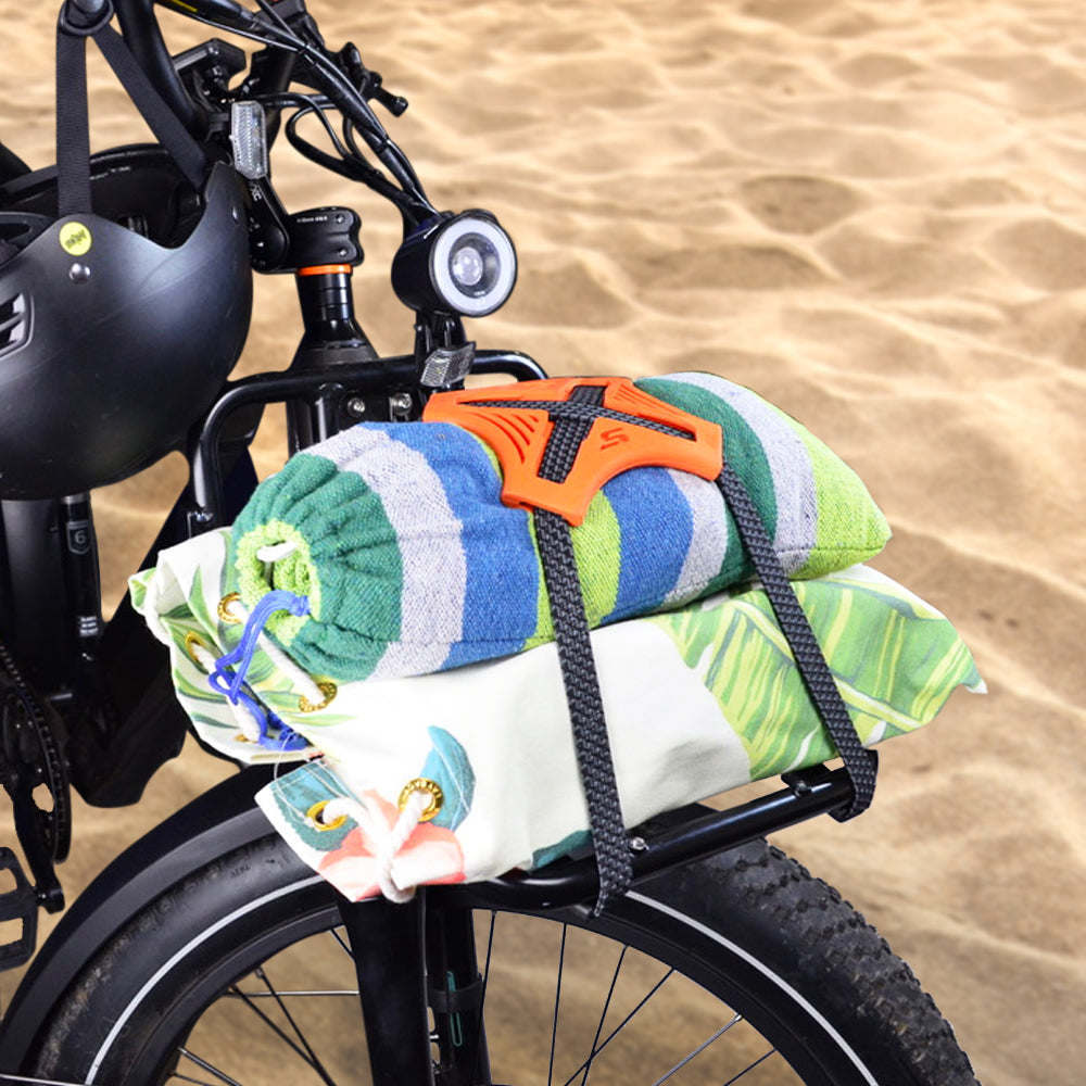 Orange Tack Strap securing towels and gear on bicycle at NZ beach